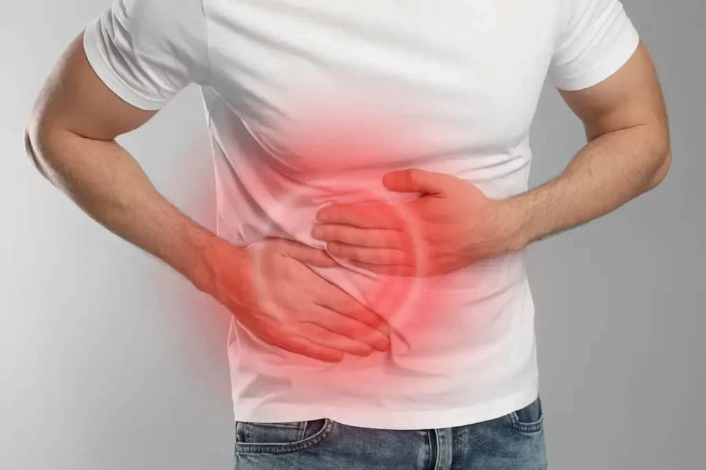 A man holds his tummy in pain due to appendicitis