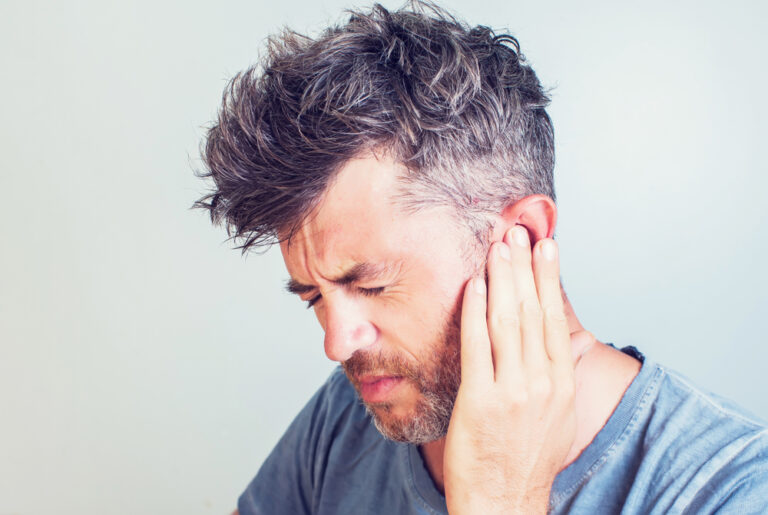 A man holds his ear in pain wants to get rid of his ear infection