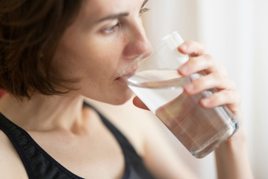 woman drinking water to help with a UTI